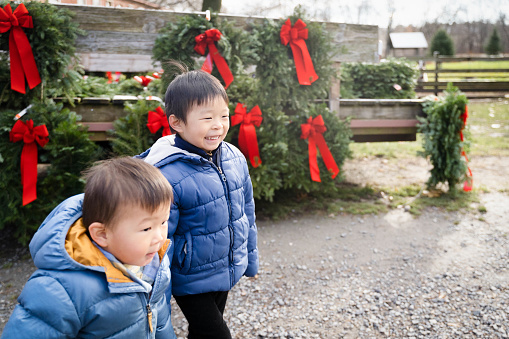 Festive Joy: Happy Boy Poses with a Christmas Wreath