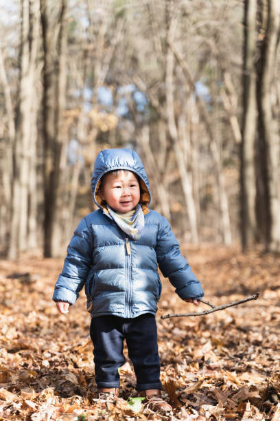The boy observes the texture of the tree trunk and gets close to nature