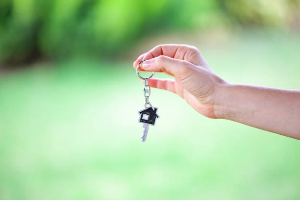 istock Woman hand holding house key. 1812750378