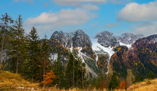 Gosausee with Dachstein mountain summit and blue lake as idyllic colorful autumn scenery background