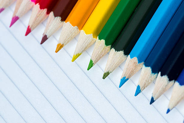 Line of coloured pencils - green pencil in focus stock photo