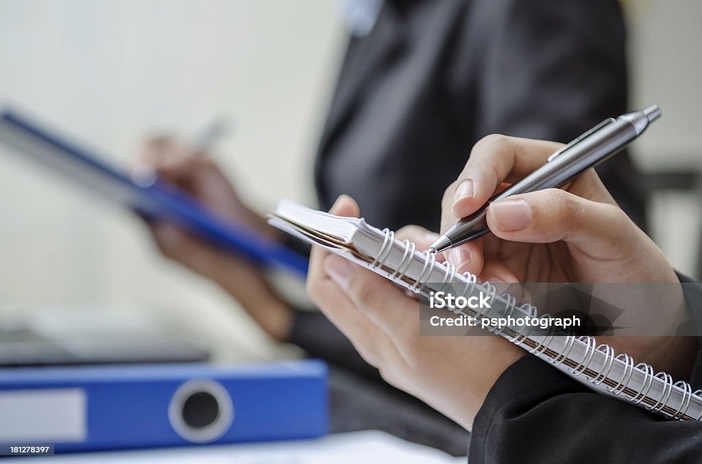 Taking note Closeup of business people writing Ballpoint Pen Stock Photo