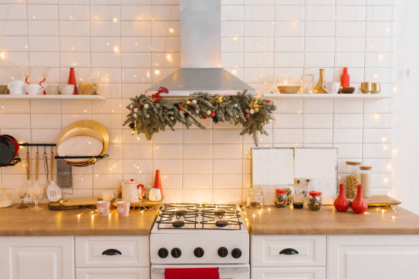 istock White wooden kitchen interior, kitchen utensils and red Christmas decor with lights in a Scandinavian cozy style. 1812786952