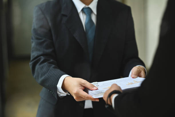 istock Financial inspector hands handing document to his colleague in office corridor 1812820343
