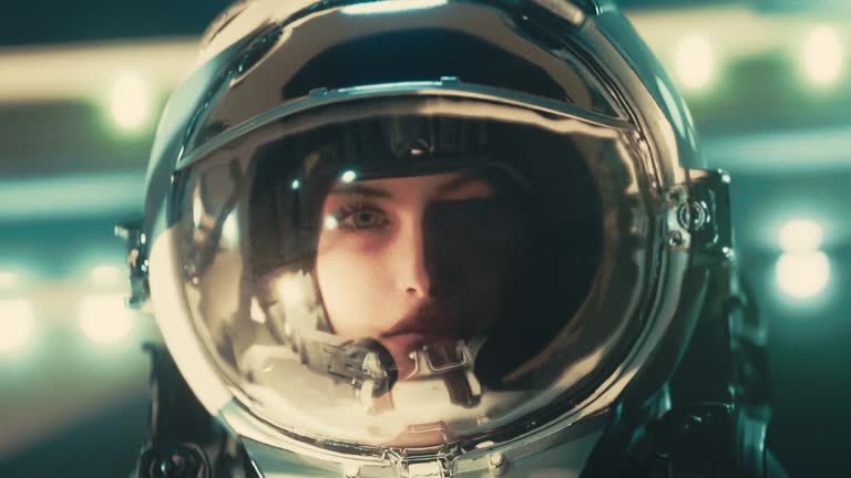 Woman,female astronaut in a glass helmet observing,shadows passing through her face. Sci-fi,science fiction cinematic animation. Scifi video.Defocused alien spaceship in the background.Alien encounter