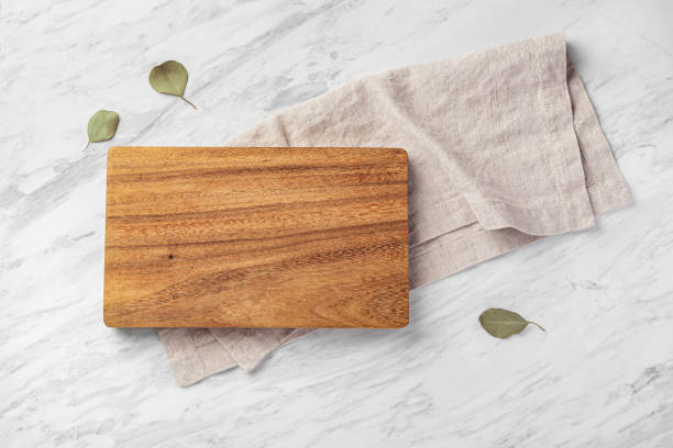 istock Wood board with linen napkin on marble kitchen countertop 1812825291