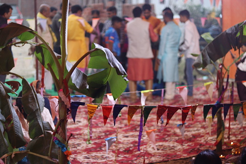 Bokeh Blur shot of crowd of people in an indian festival with paper decorations and banana leafs and sugarcane
