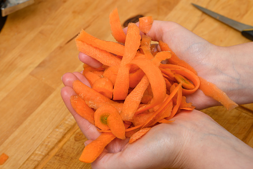 Carrot peel and peeling lie on a cutting board in the kitchen closeup