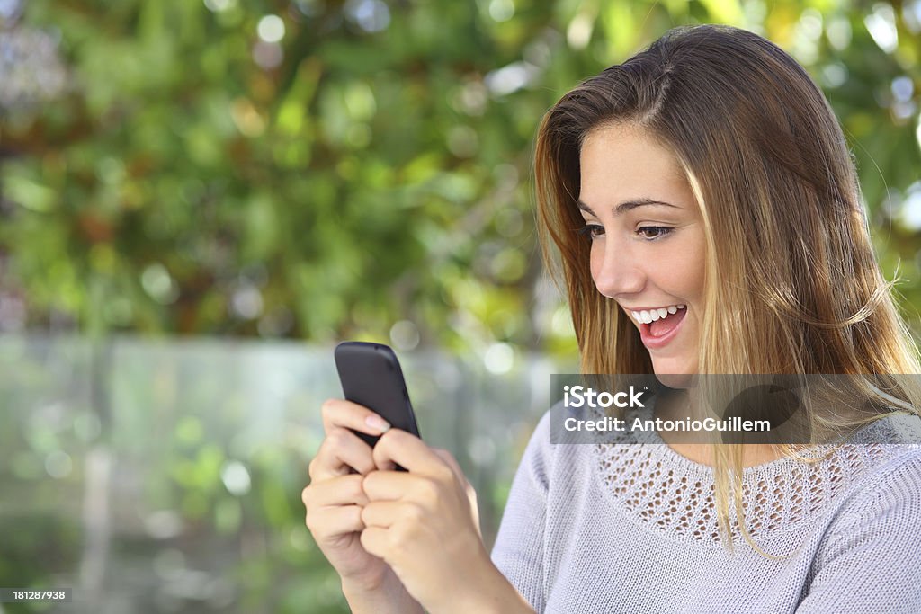 Красивые счастливая женщина, просматривая Интернет на ее смарт-телефон - Стоковые фото Беспроводная технология роялти-фри