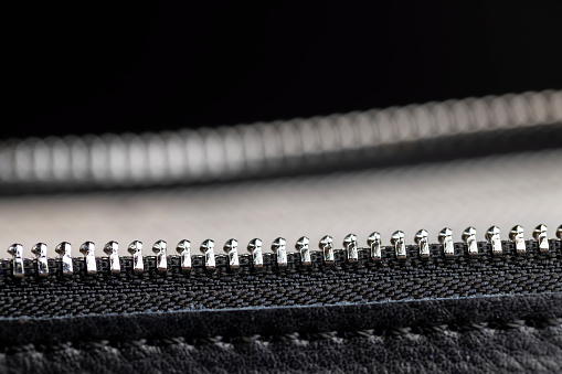 metal zipper on a black leather product, zipper on a black women's handbag close-up