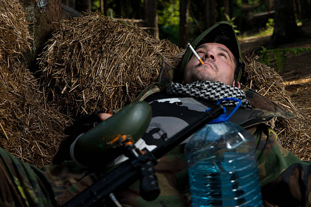 istock Paintball player resting and smoking a cigar 181290518