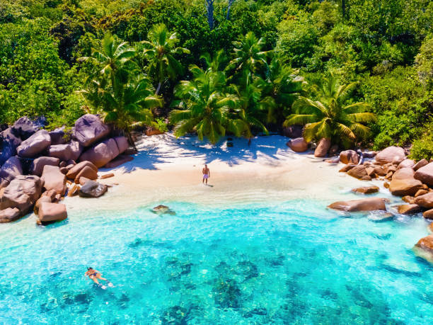 istock Praslin Seychelles tropical island with withe beaches and palm trees, couple men and women mid age on vacation at the Seychelles visiting the tropical beach of Anse Lazio Praslin Seychelles 1812906362