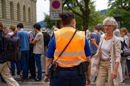 Policeman with high visibility vest at the old town of Bern on a cloudy summer day. Photo taken July 1st, 2023, Bern, Switzerland.