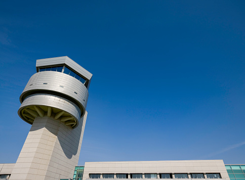 Munich international airport control tower and terminal modern buildings with departing taking off plane