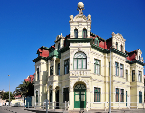 Swakopmund, Erongo district, Namibia: Hohenzollern building, Haus Hohenzollern - neo-baroque style double-storeyed building, with mansard roof - Croatian builders decorated the facade with cupids, flowers, kneeling lions and Atlas shouldering the world German Colonial Architecture - corner of Brückenstrasse and Moltkestrasse, now Tobias-Hainyeko street - national monument - photo by M.Torres