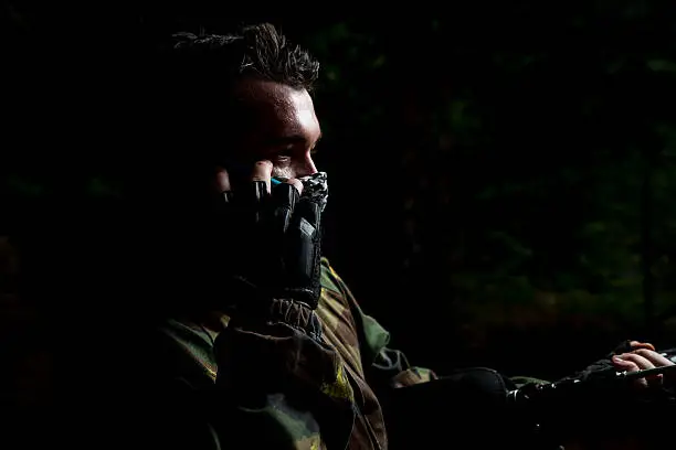 Photo of Paintball player calling someone at the phone