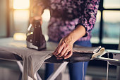 Mother is ironing a white turtleneck blouse for a teenage daughter