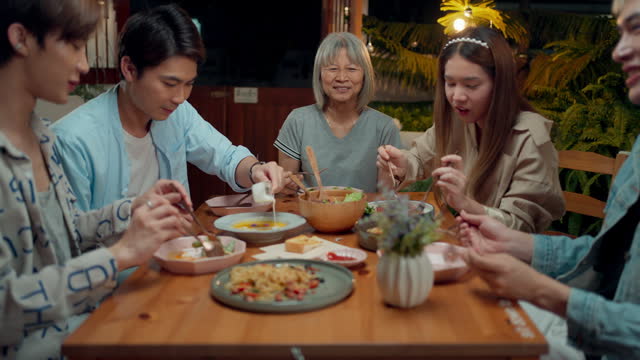 Happy Asian family enjoying with dinner meal, celebrating together with food on table in outdoor garden at home, Family relaxing with eating and drinking, Special dinner celebration with family