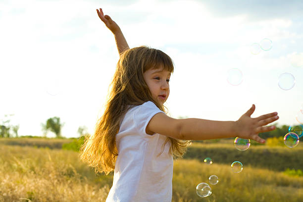istock Small positive girl catches soap bubbles 181293657