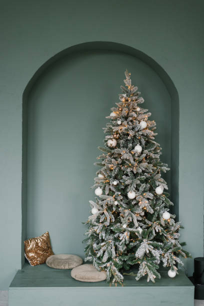 istock Stylish Christmas tree with pillows next to it in mint color 1812939180