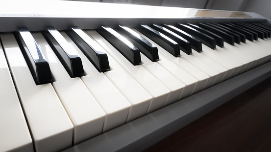 A close shot of an old wooden piano with a blurred background
