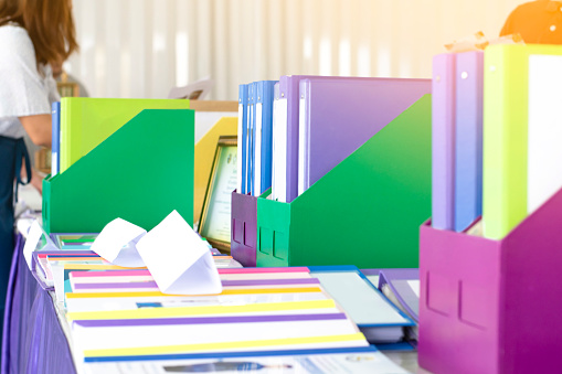 Colorful folders of personnel and office staff are kept and sorted in boxes in the office to evaluate their performance in order to raise their salary or increase their annual remuneration.