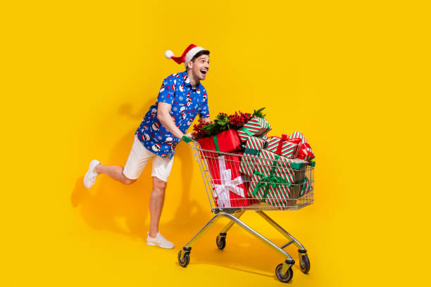 istock Full size portrait of cheerful crazy person push market trolley pile stack giftbox empty space isolated on yellow color background 1812967224