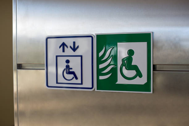 Green wheelchair sign with a person driving away from a fire. Symbol of a fireproof elevator in a building for disabled people