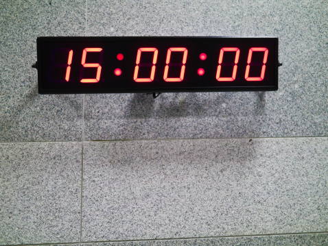 Digital clock on gray patterned wall