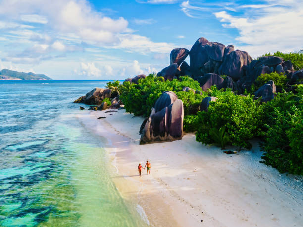 istock Anse Source d'Argent beach, La Digue Island, Seyshelles, Drone aerial view of La Digue Seychelles bird eye view, couple men and woman walking at the beach during sunset at a luxury vacation 1812974305