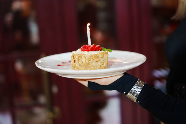 A plate of cake decorated with strawberries and a candle.