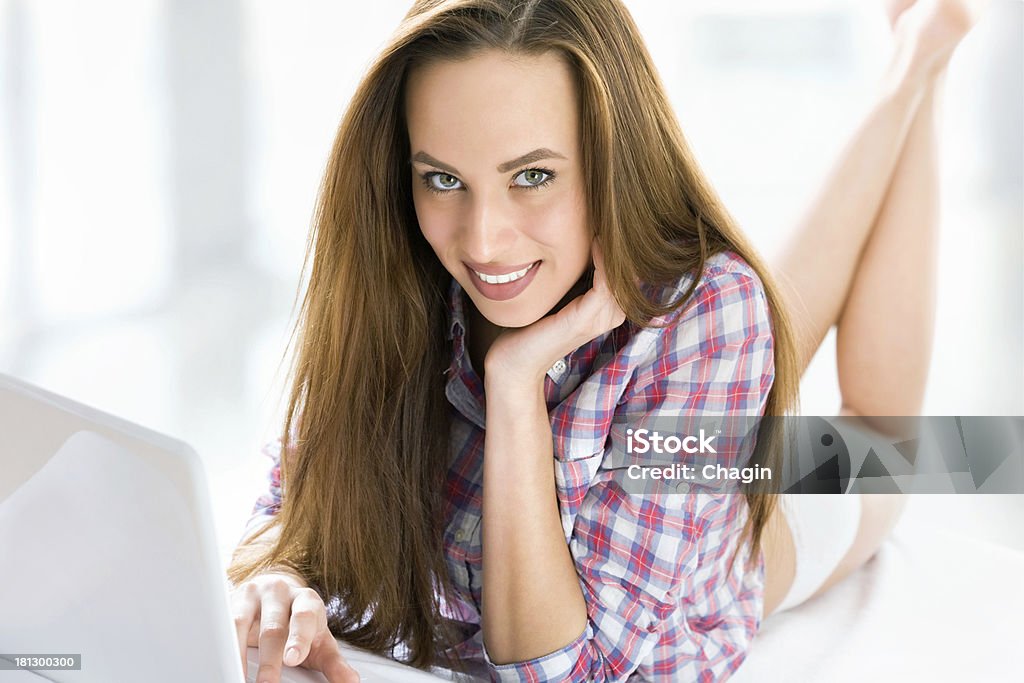 Mujer usando una computadora portátil - Foto de stock de Acostado libre de derechos