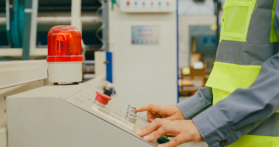 Closeup of professional Asian female industrial engineers operating machine keypad in manufacturing factory. Working in manufacturing plant or production plant concept.