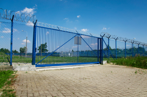 big blue gate with barbed wire
