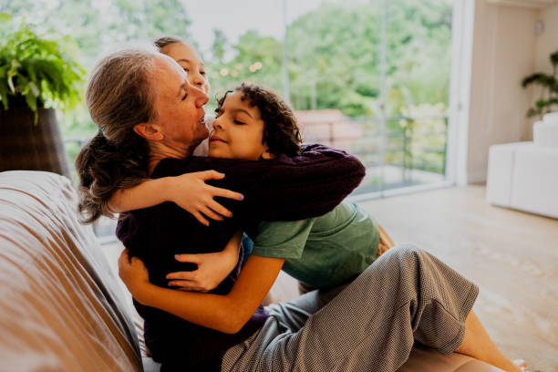 istock Mother embracing children at home 1813069881