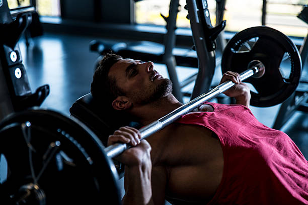 Man on an incline bench doing bench presses stock photo