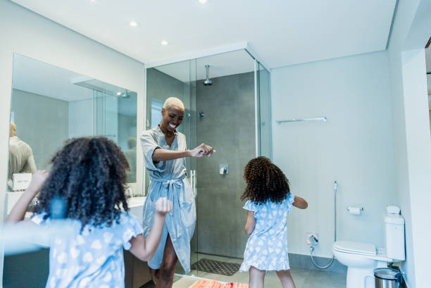 istock Mother and daughters dancing in the bathroom at home 1813074841