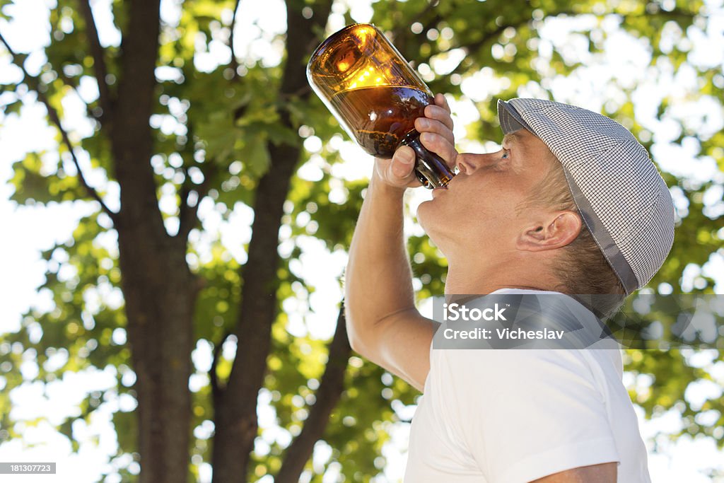 Profil Portret człowiek pije z butelki - Zbiór zdjęć royalty-free (Alkohol - napój)