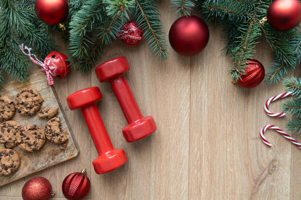 istock Fit Christmas composition with copy space. Dumbbells for gym workout, cookies, tree branches with ornaments. Seasonal healthy diet choice flat lay concept. 1813087138