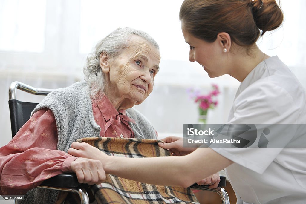 El personal de enfermería que asisten a senior mujer - Foto de stock de Tercera edad libre de derechos