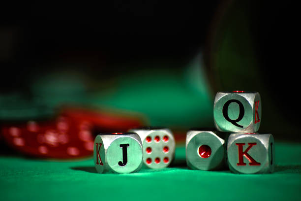 istock Cup with poker dice resting on a green mat with red chips. 1813093805