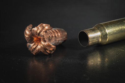 Expansive crumpled 308 caliber bullet and spent cartridge case, macro photo. High quality photo