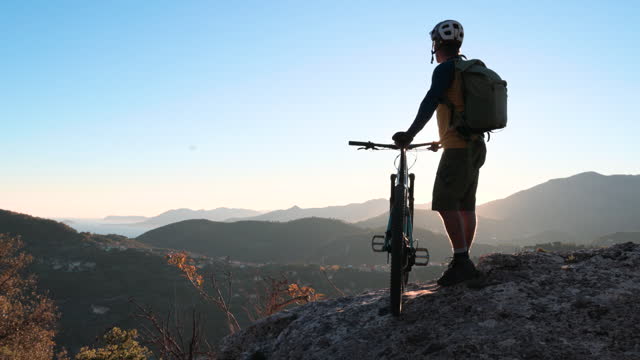 Mature male biker explores alpine mountainside, autumn