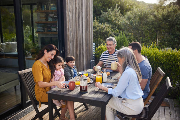 istock Smiling multi-generation family talking over lunch outside on their patio 1813198921