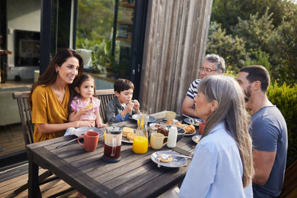 istock Smiling multi-generation family talking while eating lunch outside on their patio 1813199501
