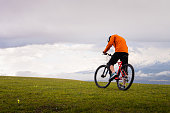 Professional mountain biker on the background of mountains and green hills. Tired mtb rider in full face helmet outdoors