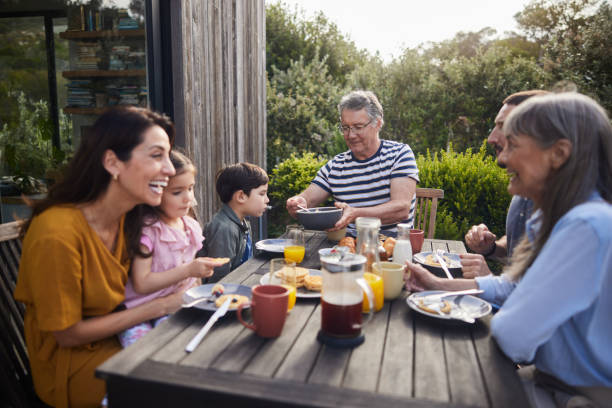 istock Multi-generation family laughing while eating lunch outside on their patio 1813200538