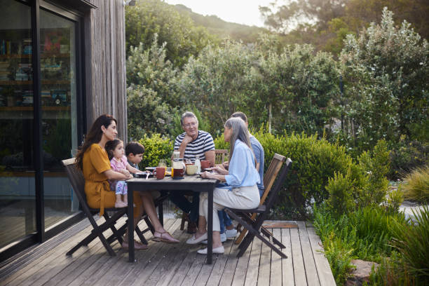 istock Multi-generation family talking together while eating lunch on their patio 1813201094