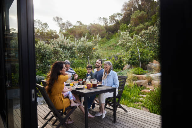 istock Smiling multi-generation family talking together while eating lunch on their patio 1813201633