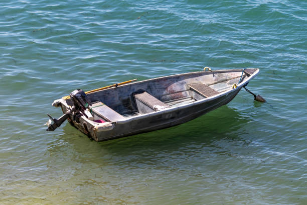 Small motorboat anchored in Morro Bay, California. Floating on the green water.